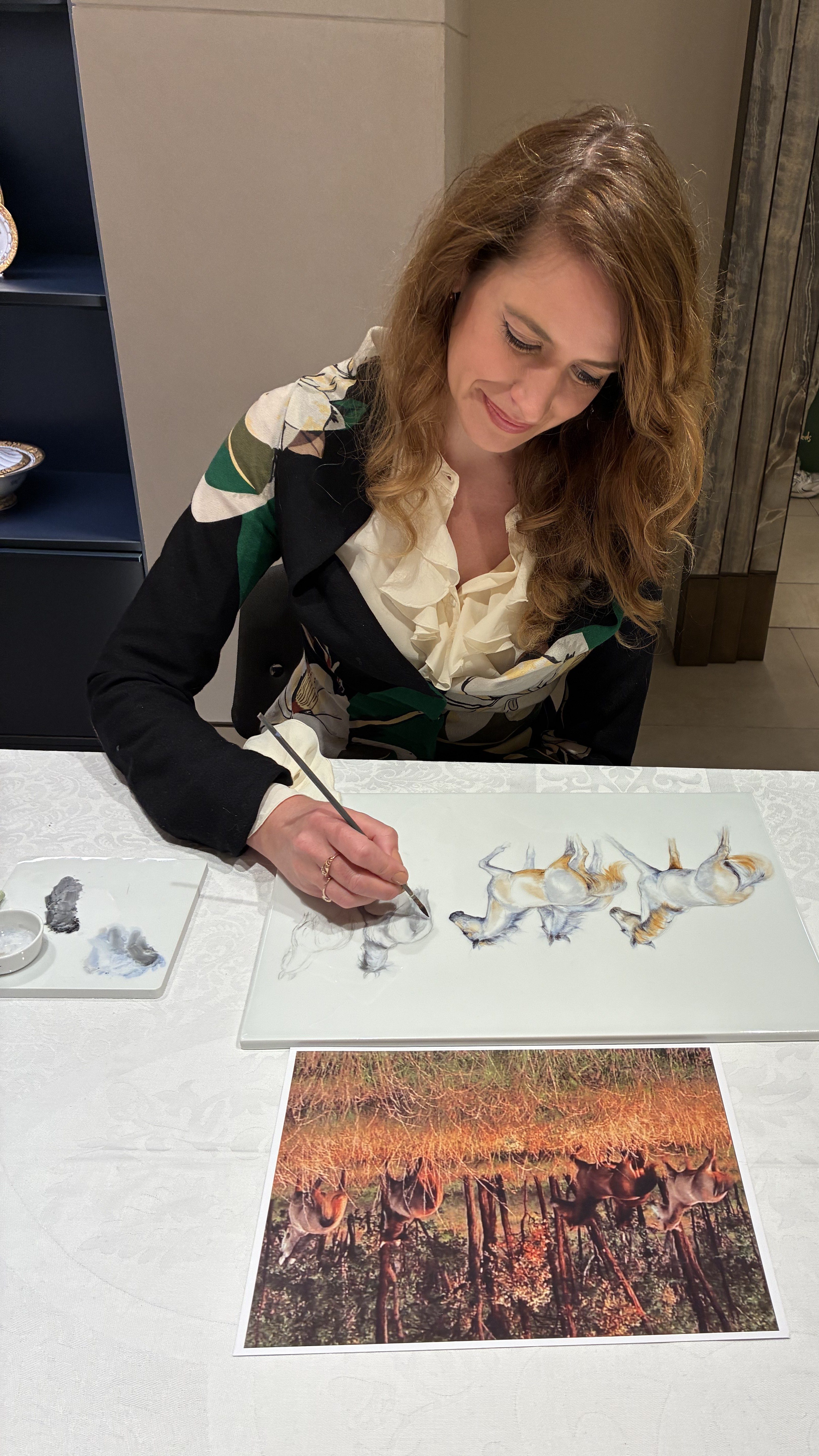 Künstlerin Michaela Stocker malt auf Porzellan in einem eleganten Raum in dem renommierten Londoner Kaufhaus Harrods.